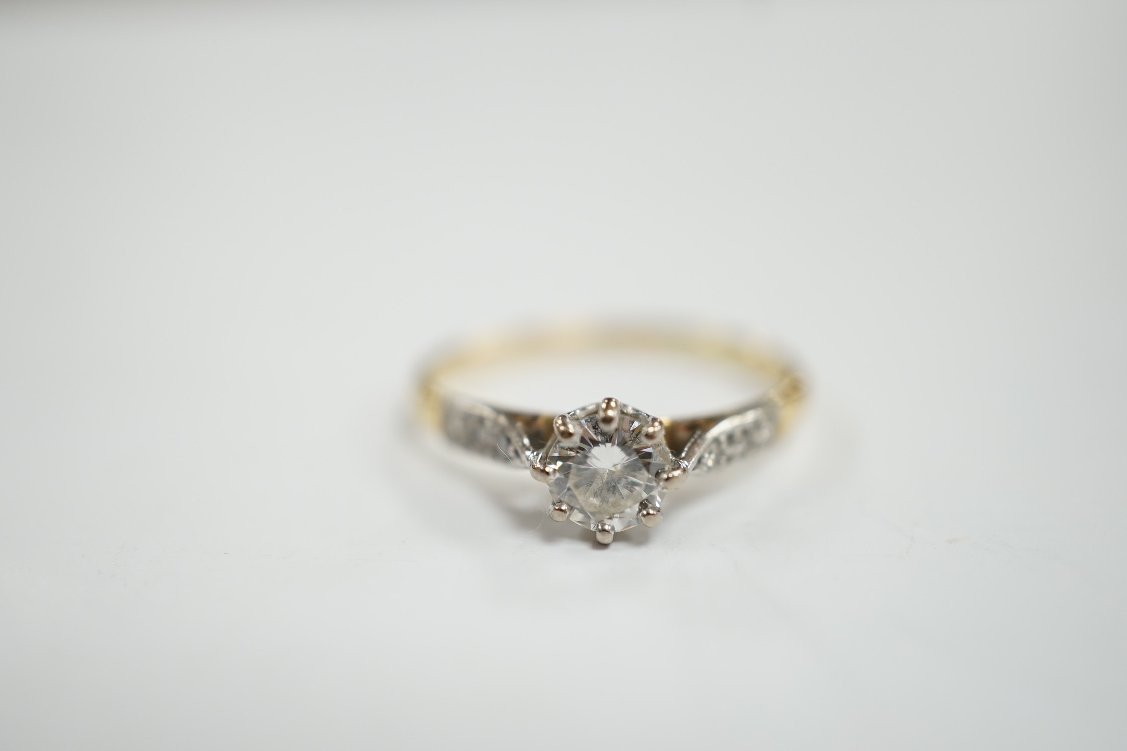 An 18ct and single stone diamond set ring, with diamond chip set shoulders, size M, gross weight 1.9 grams.